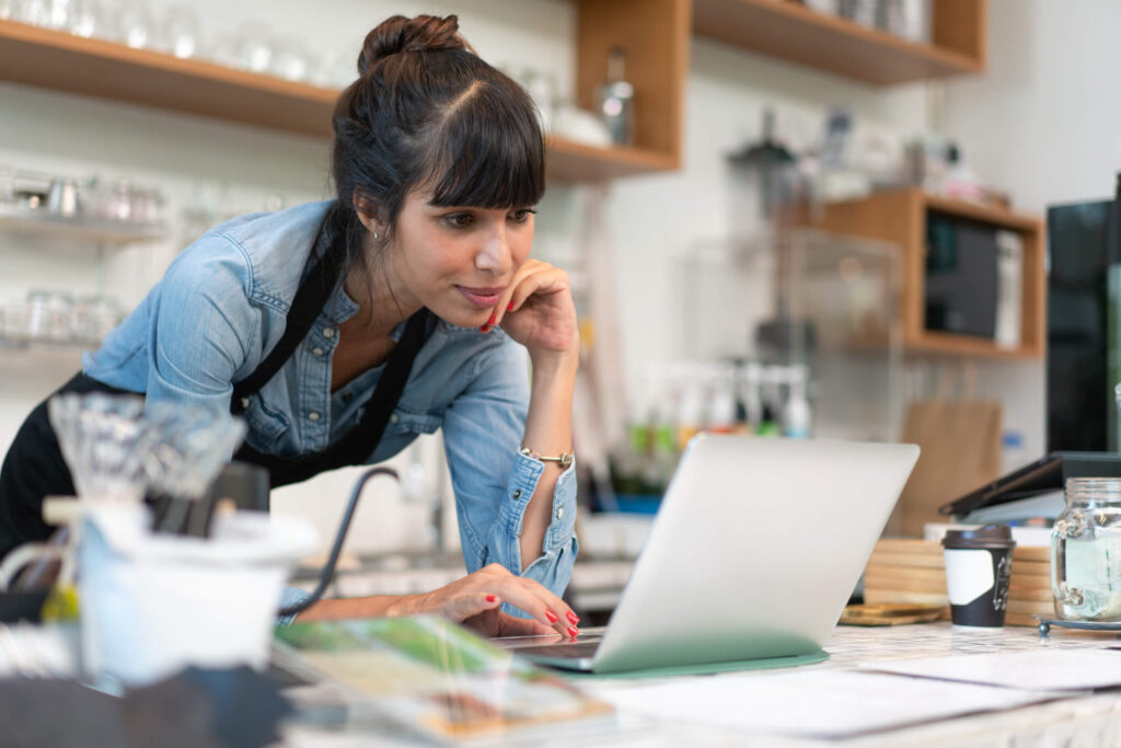 A Washington small business owner reviews Annual Report paperwork at a desk with a laptop and a calendar, highlighting filing deadlines and fees.